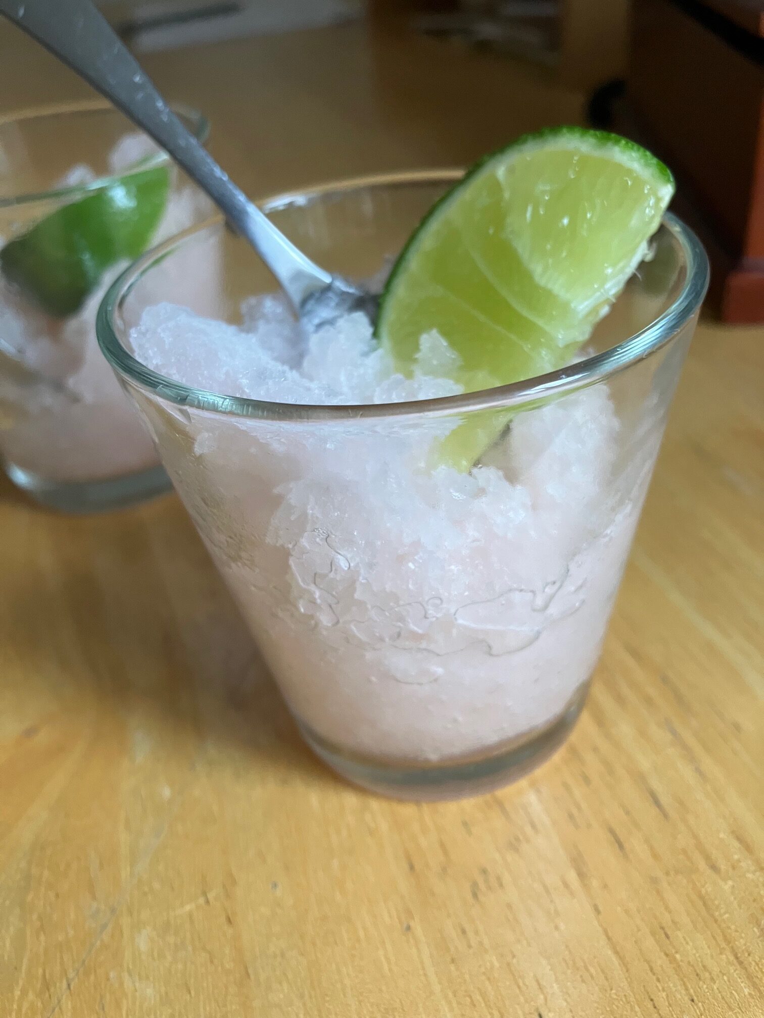 Guava lime granita in a cup with a wedge of lime
