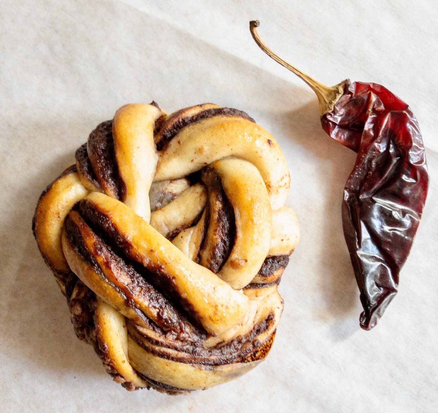 10/18 UWS: Spooky and Spiced variety box chocolate chili babka bun next to a red guajillo chile